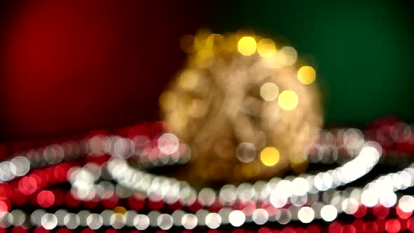 Unusual Gold Toy for Christmas or New Year and Beads, Rotation, on Red and Green, Bokeh, Dynamic