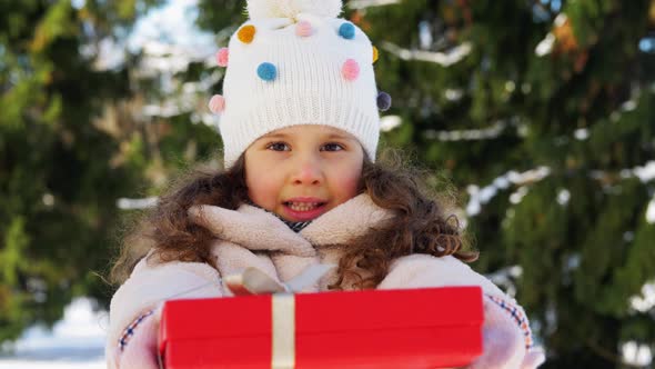 Happy Girl with Christmas Gift in Winter Park