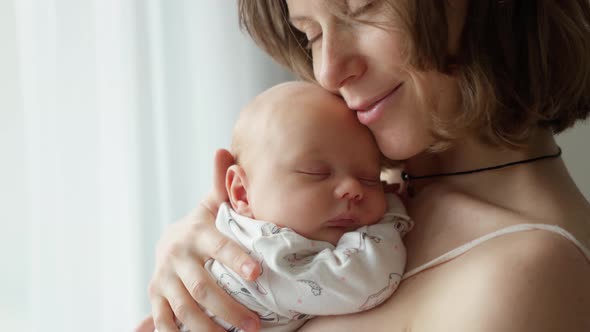 Mother Holding a Newborn Baby in Her Arms