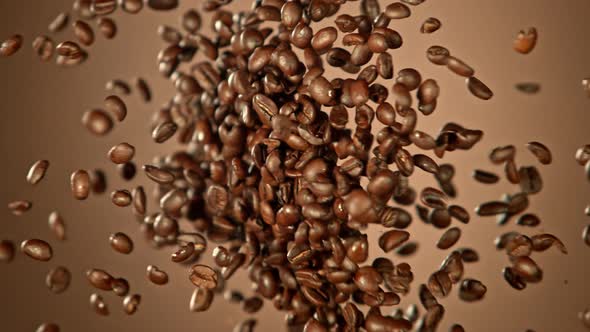 Super Slow Motion Shot of Crashing Coffee Beans on Brown Gradient Background at 1000Fps.