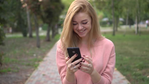 Girl Is Using Smartphone on Street