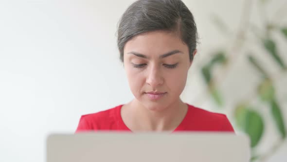 Close Up of Indian Woman Looking at Camera While Using Laptop