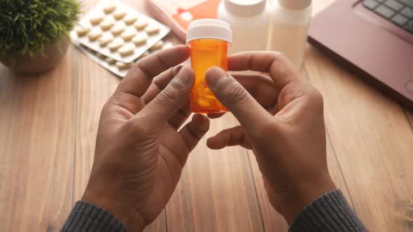 Young Man Hand Holding Medicine Pill Container