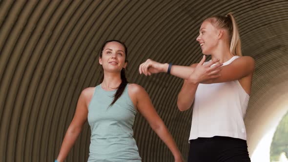 Women with Fitness Trackers Stretching Outdoors