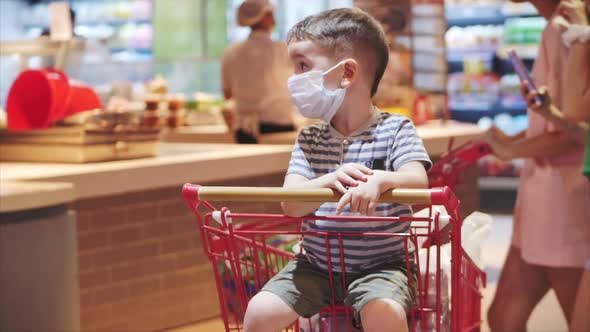 Young Woman in a Mask From a Coronavirus Epidemic Is Standing in the Grocery Department of the