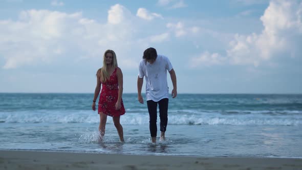 Young Beautiful Couple Walking From the Sea in Wet Cloth