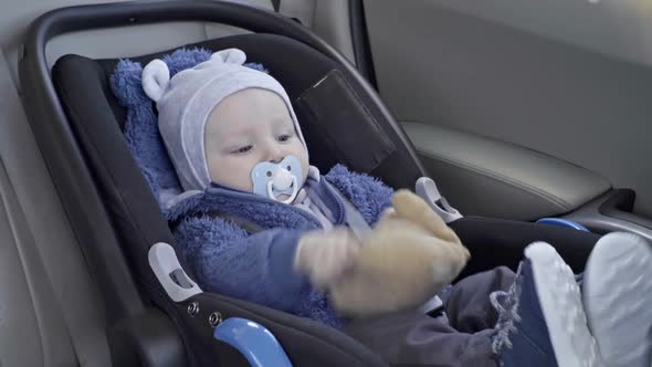 Little Baby Playing with Toy in Car Seat