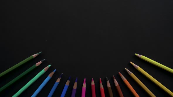 Wooden School Pencils of Different Colors Are Located on the Black Surface. Stop Motion Animation