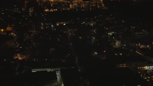 Aerial view of the parthenon temple on acropolis hill at night in Athens.