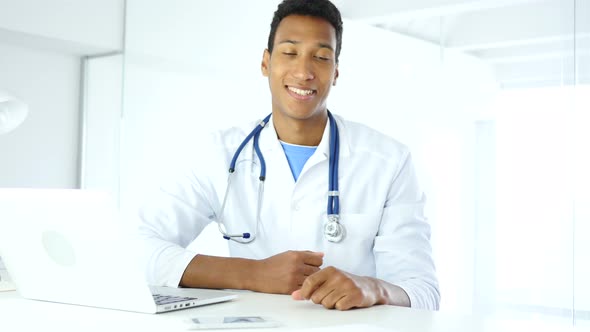 African Smiling Positive Doctor in Clinic Looking at Camera