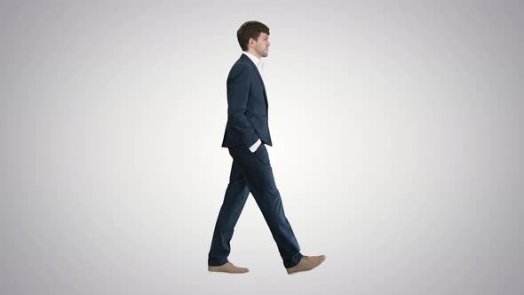 Handsome Business Man Walking with His Hands in Pockets on Gradient Background