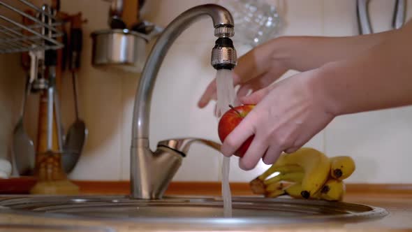Woman Turns on a Tap Washes Ripe Red Apple in Sink Turns Off Water