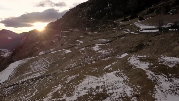 Low flight over the Tarter mountains, Andorra, at sunset time, the clouds reflect the beautiful ligh