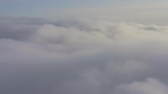 Aerial View Flying Through Cumulus Clouds at Sunset