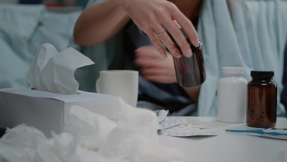 Close Up of Woman Reading Labels of Tablets and Jars with Pills and Capsules