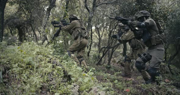 Squad of fully armed commando soldiers during combat in a forest scenery alt