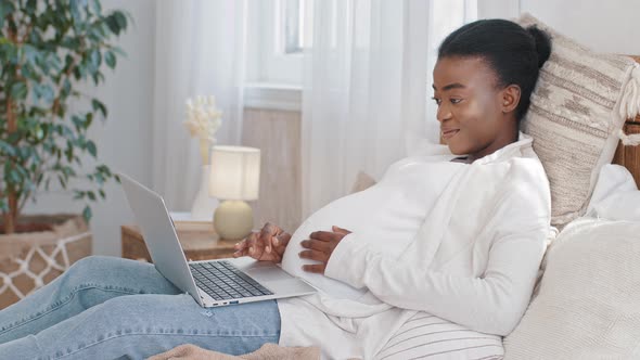 Afro American Expectant Mother Black Ethnic Woman Lying on Bed Stroking Pregnant Belly Enjoying