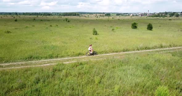 Woman Riding a Bicycle on a Rural Road