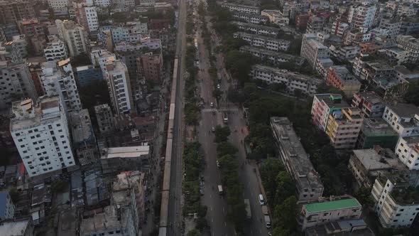 Drone flight shows train and traffic flow along highway in Dhaka city, Bangladesh