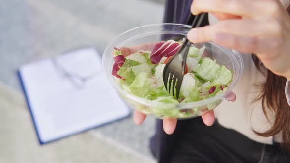 Close up of businesswoman eating salad on lunch break