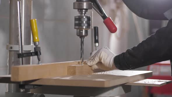 Woodworker Drills Holes in Wooden Plank with Drilling Machine in Slow Motion