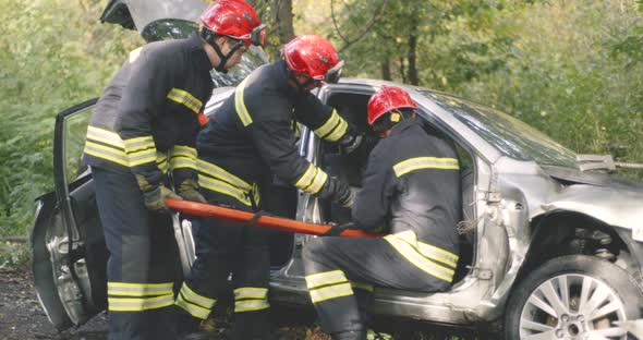 Firemen Saving Unconscious Man From Broken Car