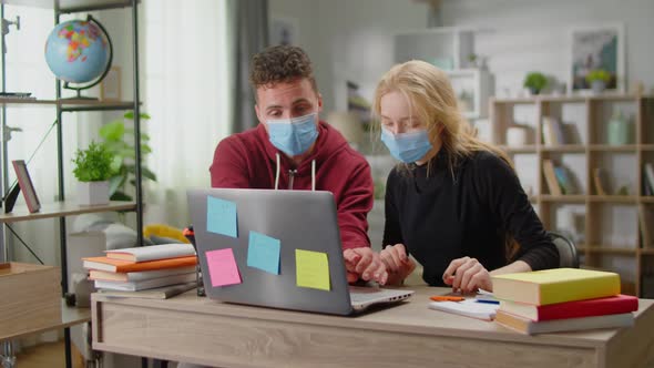 Young Tutor Man is Studying with a Young Woman at Her Home During Quarantine