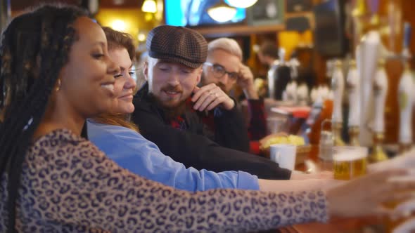 Happy Smiling Friends Drinking Beer Talking at Bar or Pub