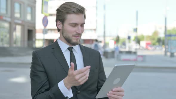 Video Call on Tablet By Businessman Outdoor