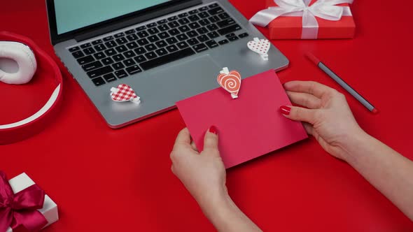 Woman's Hands Open a Festive Envelope Decorated with a Decorative Heart and Take Out a Love Card