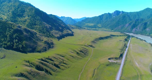 Aerial Rural Mountain Road and Meadow at Sunny Summer Morning