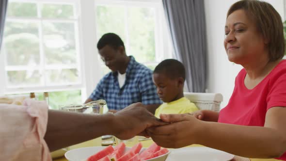 Animation of african american family praying before meal at home