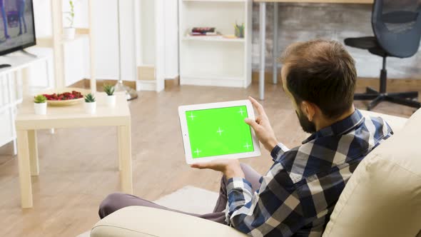 Man Holding Horizontally a Green Screen Digital Tablet PC