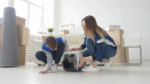 Young Mom and Son with Their Cat Are Moving To a New Apartment