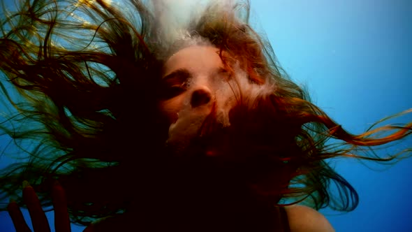 Underwater Shot with Mermaid or Waternymph with Swaying Hair in Blue Background Slow Motion