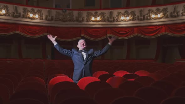 Happy rich man in empty theater hall. 