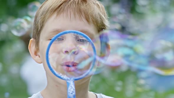 Boy Blowing Soap Bubbles at Camera alt