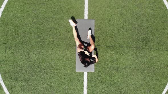 Aero, Top View, Fitness Woman in Sportswear Doing Various Exercises on Sports Mat, on Green Football