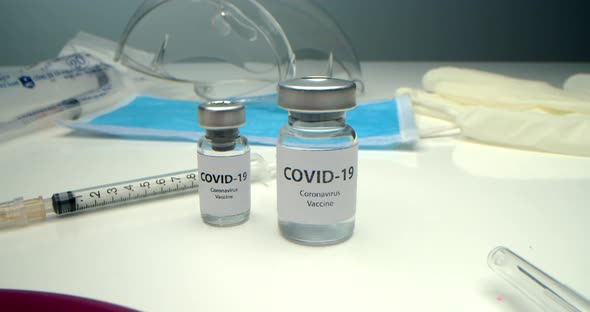 Vaccine Against COVID19 an Ampoule with a Vaccine Against Coronavirus and Various Syringes Nearby