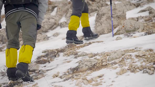 Two Men Are Climbing in Mountains in Winter Day, Moving Up During Hiking, Back View of Travelers