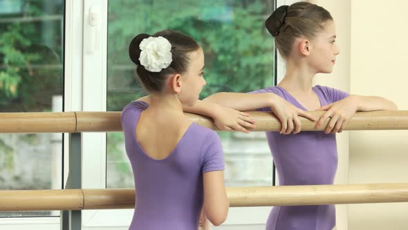 Smiling Little Ballerinas Standing at Barre