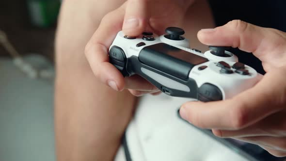 Closeup of the Hands of a Young Man Playing Video Games on a Game Console