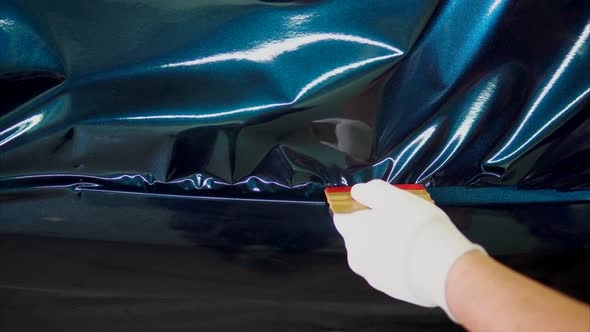 Close Up Shot of Man's Hands Removes Air Bubbles While Tuning Car