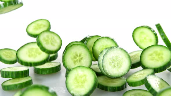 Super Slow Motion Shot of Cucumber Slices Falling on White Background at 1000Fps