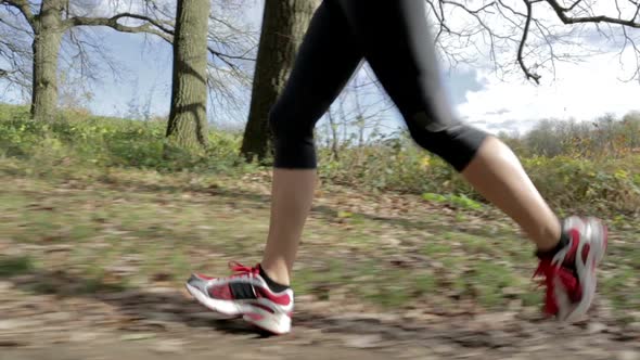 Woman Running Over Meadow Close side view