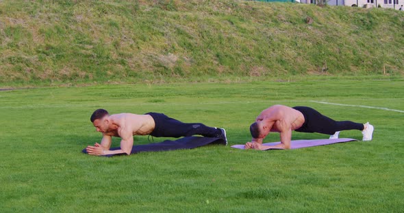 Shirtless Men Doing Plank Exercise Outdoors