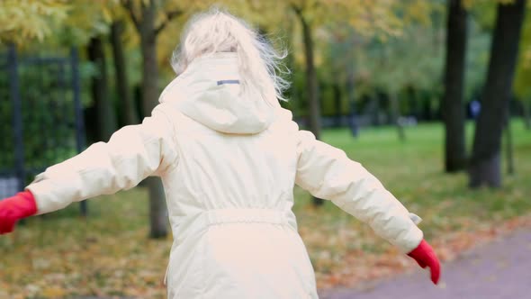 Little Girl Having Fun Spinning Outdoor in Autumn Orange Park