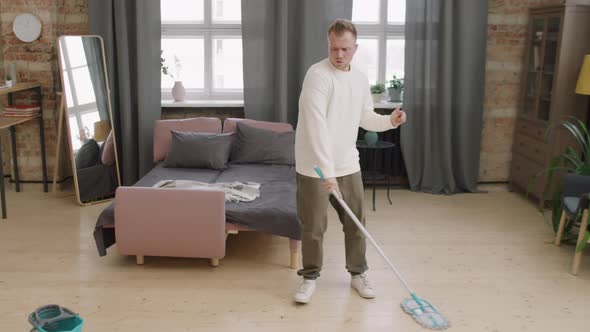 Young Man Dancing and Cleaning at Home