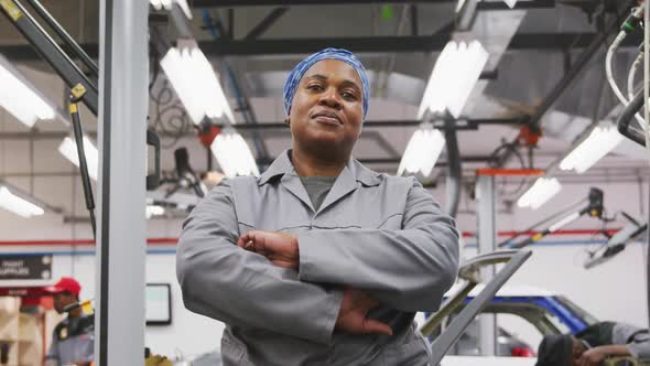 African American female car mechanic crossing her arms and looking at camera