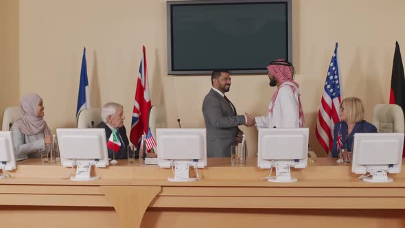 Male Politicians Shaking Hands at Press Conference